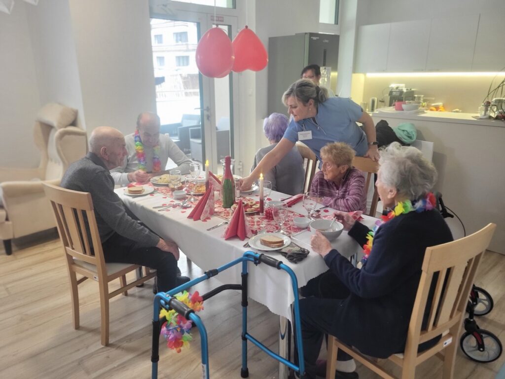 Vyzdobený stôl, za ktorým sedia starí ľudia