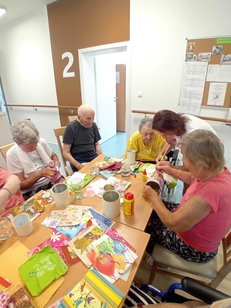 Seniori vyrábajú dekorácie z plechoviek a servítok počas tvorivej dielne