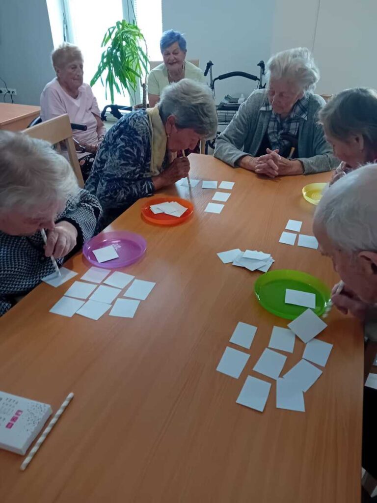 Tréning pamäti pre seniorov – fúkanie papierikov pomocou slamiek ako skupinová aktivita