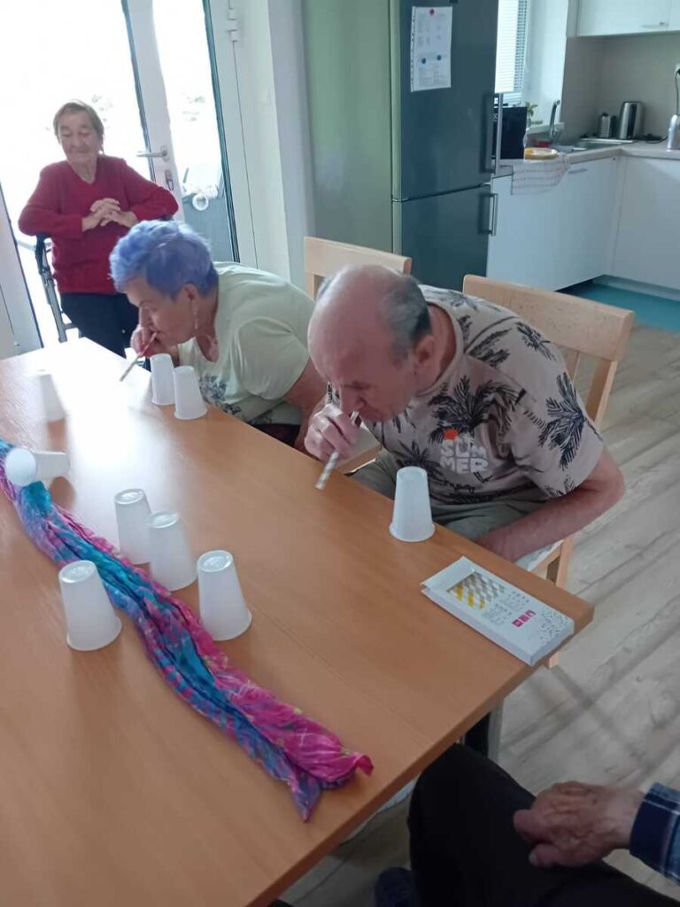 Spoločná fotografia seniorov a personálu s diplomami po tréningu pamäti v Harmónii