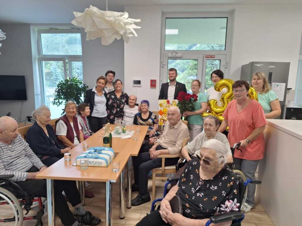 Spoločná oslava výročia zariadenia Harmónia so seniormi a personálom pri slávnostnom stole