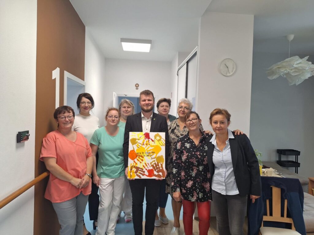 Spoločná fotografia zamestnancov zariadenia Harmónia s pamätným obrazom vytvoreným klientmi