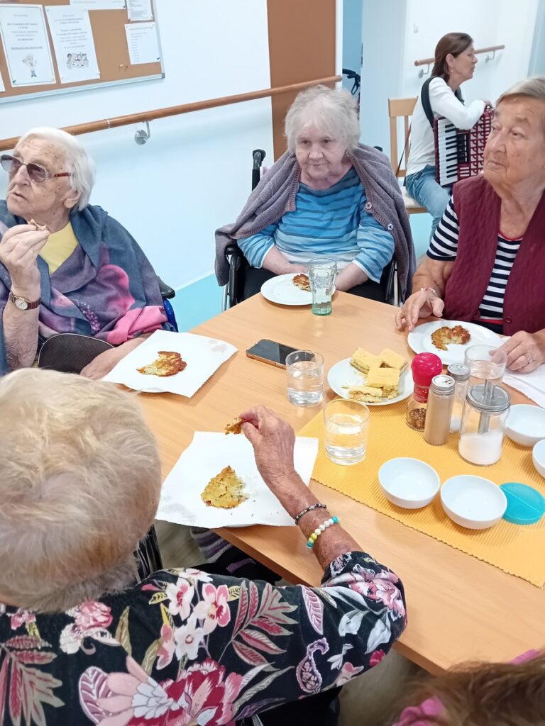 Seniori si vychutnávajú čerstvo pripravené zemiakové placky počas spoločného stolovania