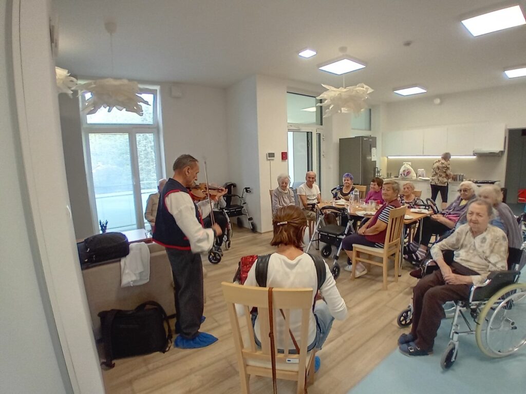 Hudobné vystúpenie pre seniorov v spoločenskej miestnosti zariadenia Harmónia