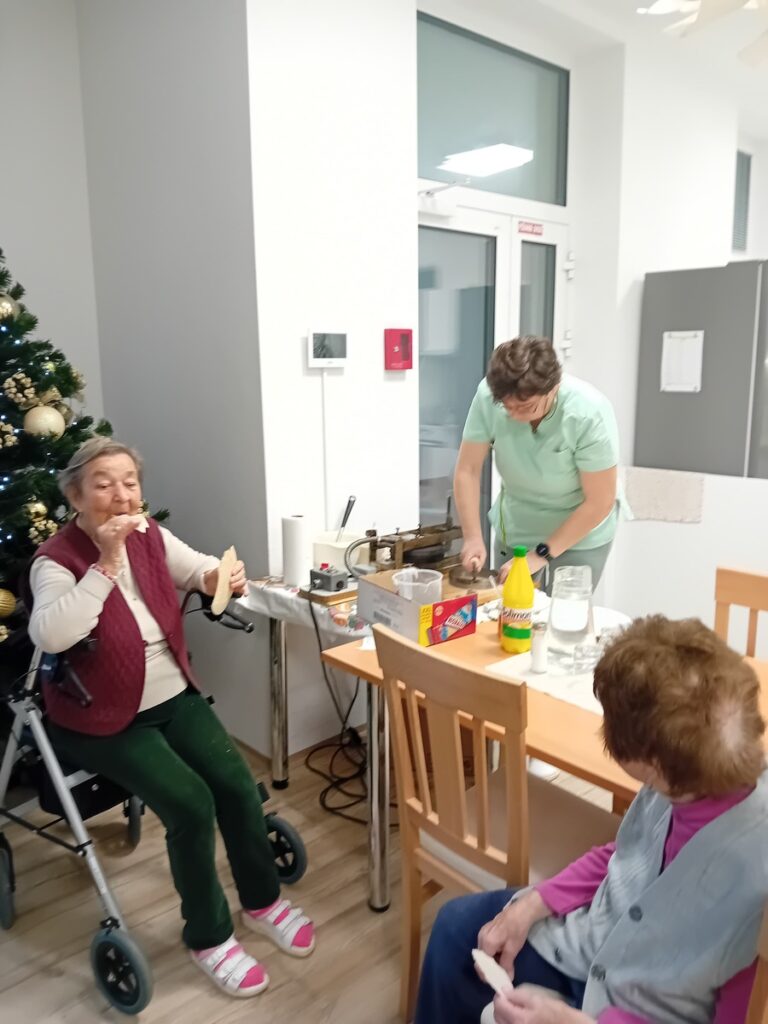 Personál Harmónie s dôchodkyňami pri tvorbe oblátok